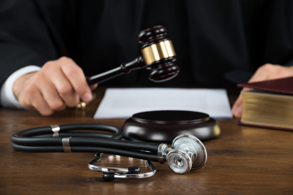 Summary Judgment - Judge Striking Mallet With Stethoscope At Desk